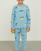 Child wearing blue pajamas with vehicle patterns on a plain background