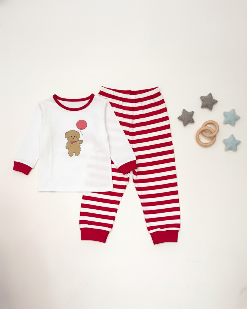 Children's red and white pajama set with teddy bear design on a light gray background.