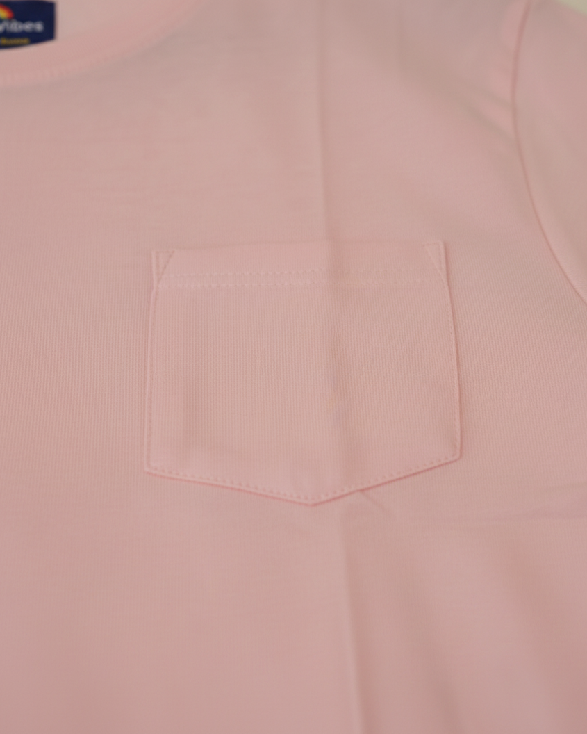 Close-up of a pink shirt with a pocket, brand label visible.