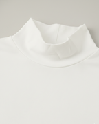 Close-up of a white mock neck tshirt on a light gray background