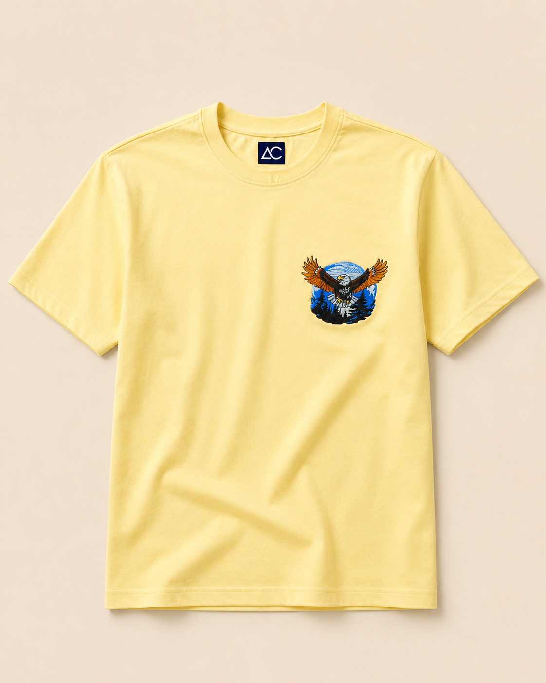 Eagle embroidered Cream Regular Fit T-shirt placed on the Light Beige Background