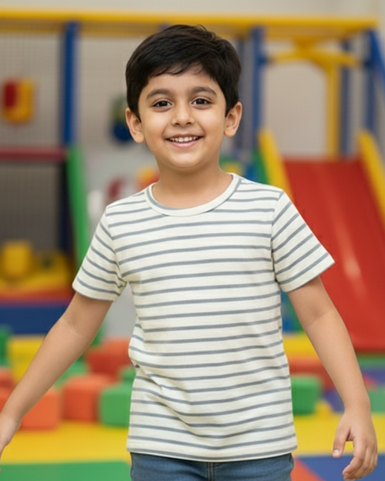 Child standing in front of a colorful playground with slides and climbing structures.