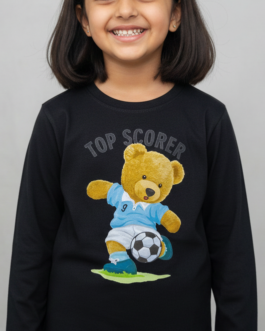 Young girl wearing a black sweatshirt with a teddy bear graphic and 'Top Scorer' text on a gray background