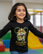 Girl wearing a black long-sleeve shirt with a colorful graphic design in a playroom.