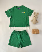 Green children's outfit with shorts and a t-shirt on a white background