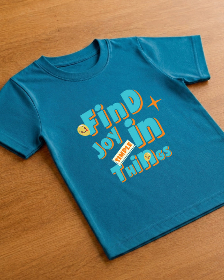 Joy print in Kids Teal Blue T-shirt placed on wooden floor