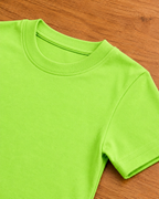 Light Lime Green T shirt  placed on the wooden background close view