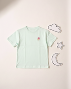 Light blue t-shirt with a small design on a light pink background