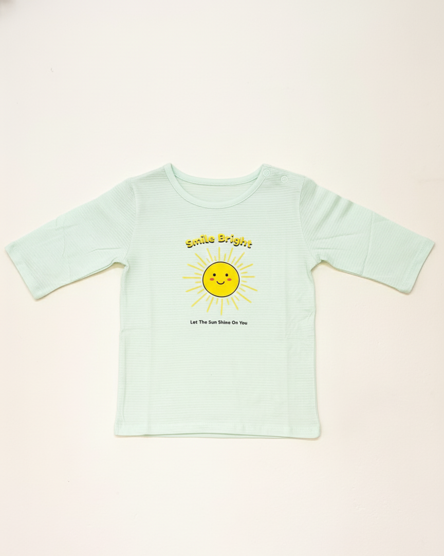 Light blue t-shirt with a sun graphic and text on a light pink background