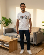 Man standing in a living room wearing a white t-shirt with a graphic design.