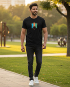 Man walking in a park wearing a black t-shirt with a colorful logo