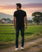 Man walking on a dirt path in a field with a scenic background