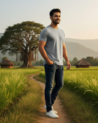 Man walking on a path through a lush green field with huts and trees in the background