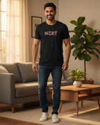 Man wearing a black t-shirt with 'NEXT' printed on it in a living room.