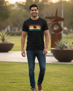Man wearing a black t-shirt with a colorful graphic design outdoors.