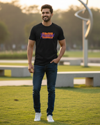 Man wearing a black t-shirt with colorful text in an outdoor setting
