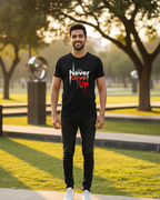 Man wearing a black t-shirt with motivational text in an outdoor setting