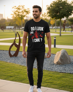 Man wearing a black t-shirt with text and graphics in an outdoor setting