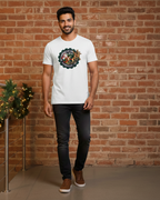 Man wearing a white t-shirt with a logo against a brick wall.