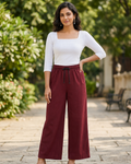 Women in a park wearing a white square neck t-shirt and burgundy palazzo pant