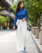 Women wearing a blue mock neck t-shirt paired with white palazzo pant 