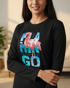 Person wearing a black long-sleeve shirt with a flamingo graphic and text indoors.