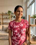 Person wearing a red and white tie-dye shirt in a living room setting