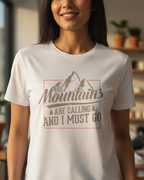 Person wearing a white t-shirt with a mountain design and text in a casual setting.