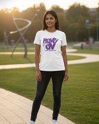Person wearing a white t-shirt with purple text in an outdoor setting