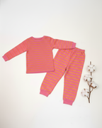 Pink and orange striped pajama set on a white background with cotton branches.