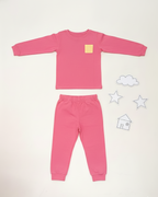 Pink children's pajama set on a white background with decorative elements.