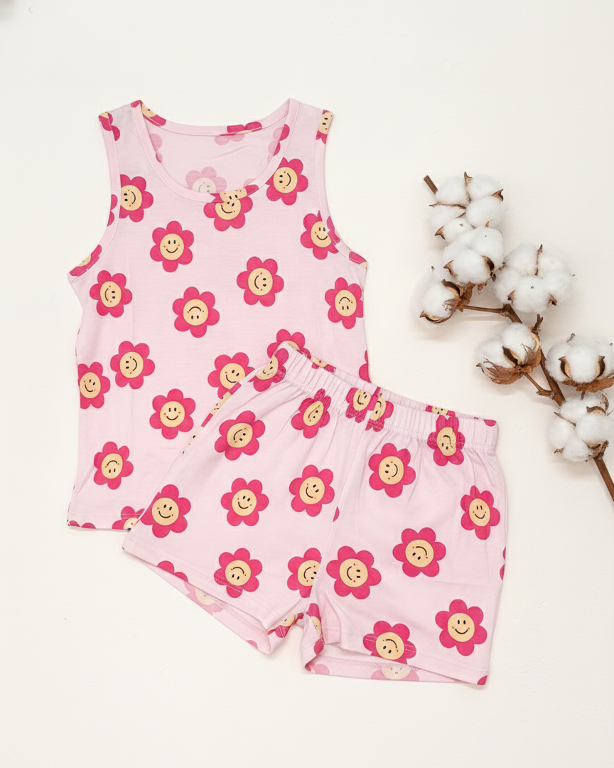 Pink children's sleeveless top and shorts set with flower pattern on a white background.