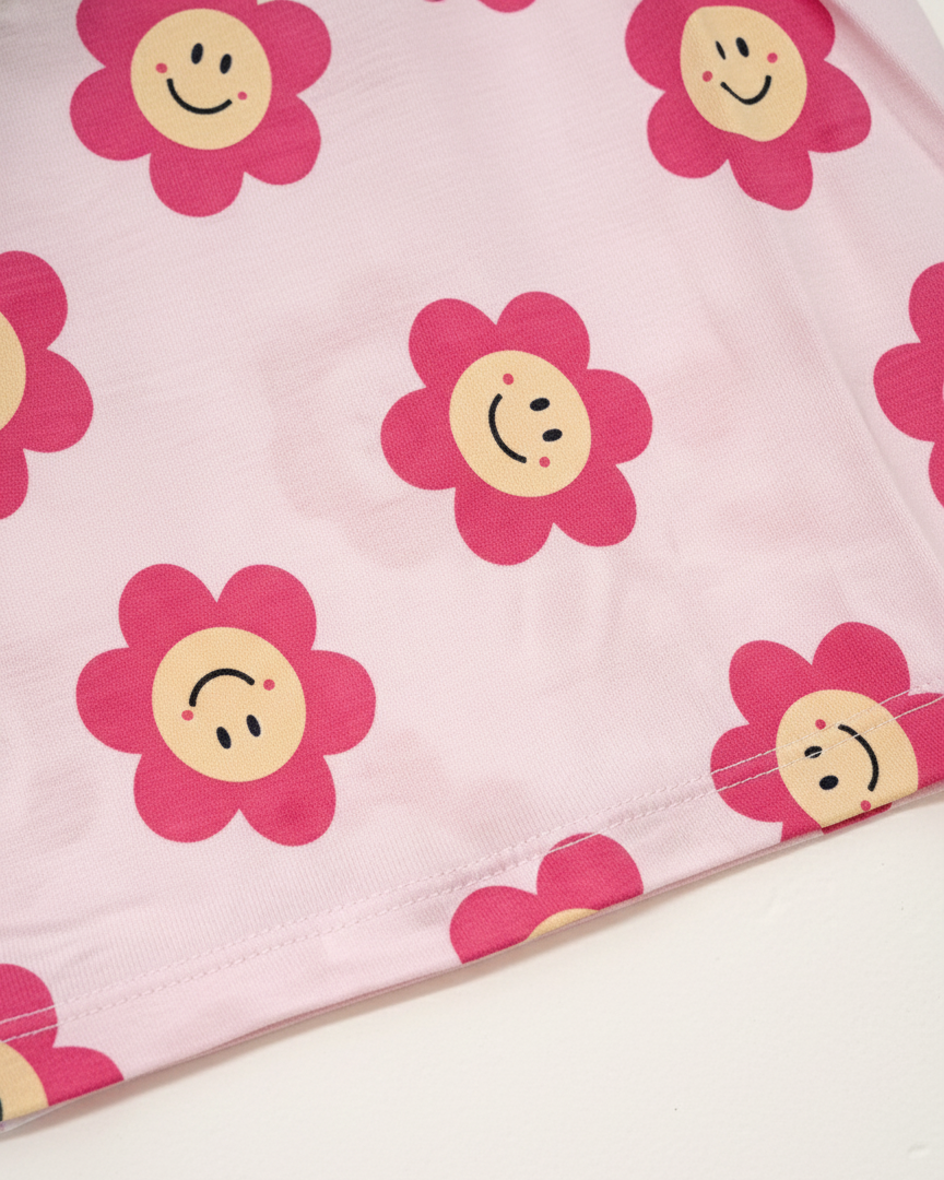 Pink fabric with smiley face flowers on a white background