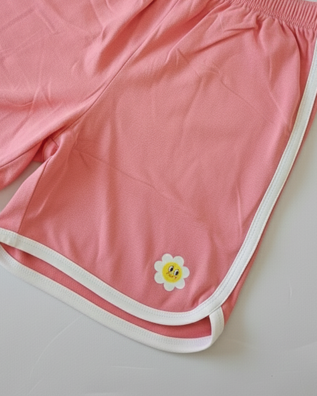 Pink shorts with a white border and a yellow flower design on a light gray background