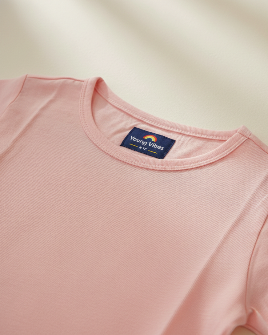 Pink t-shirt with a brand label on a beige background