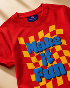 Closeup view Red colour T shirt with Make it fun print placed in light beige background