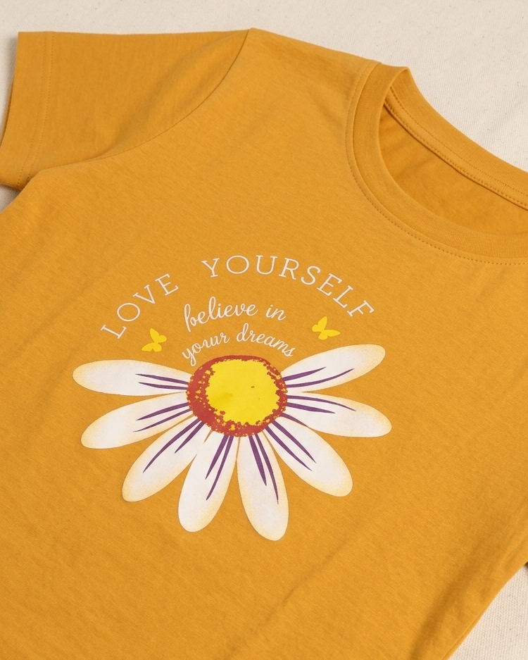 Rust orange T-shirt with Sunflower print placed on the light beige background close view