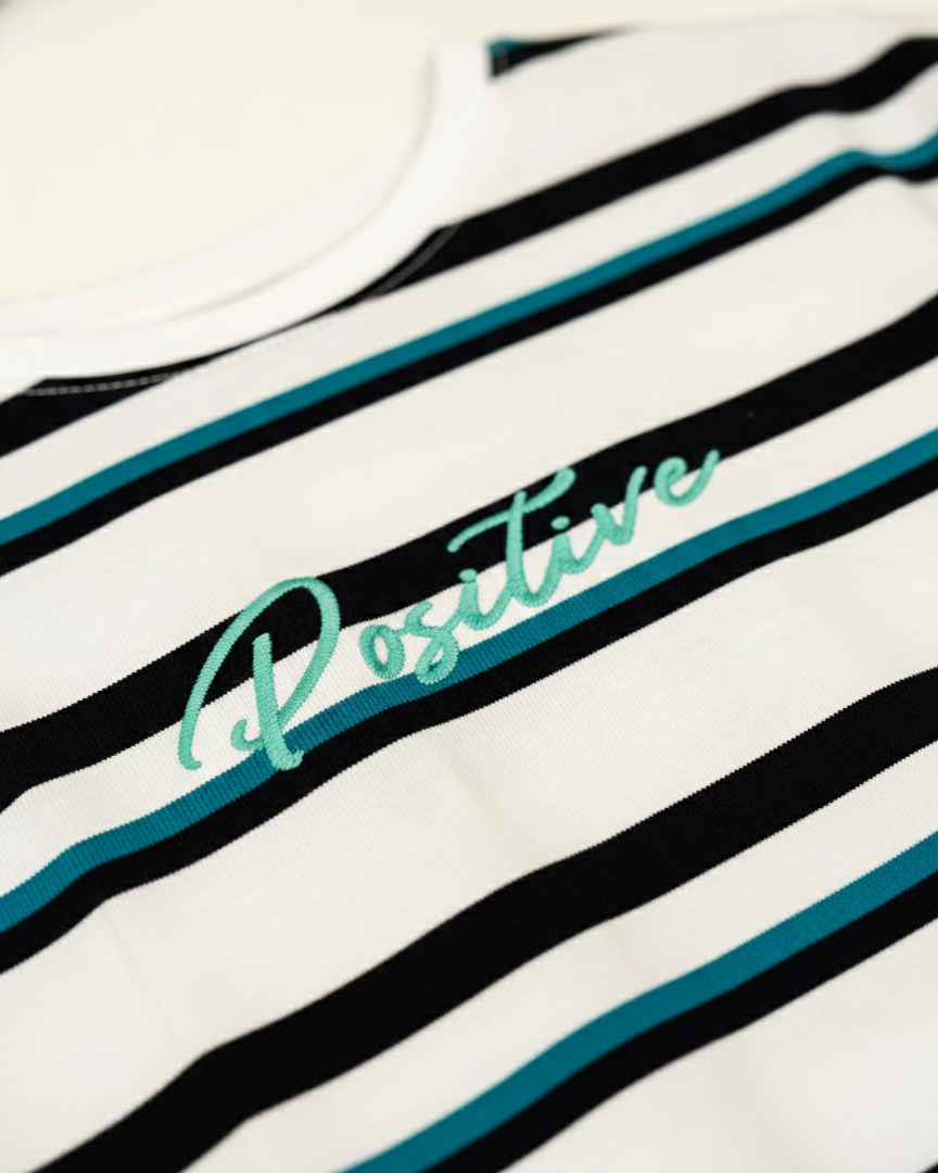 Striped shirt with 'Positive' text on a white background