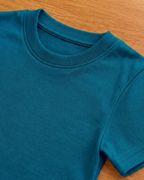 Teal Blue t-shirt with round neck and half sleeve on a beige background