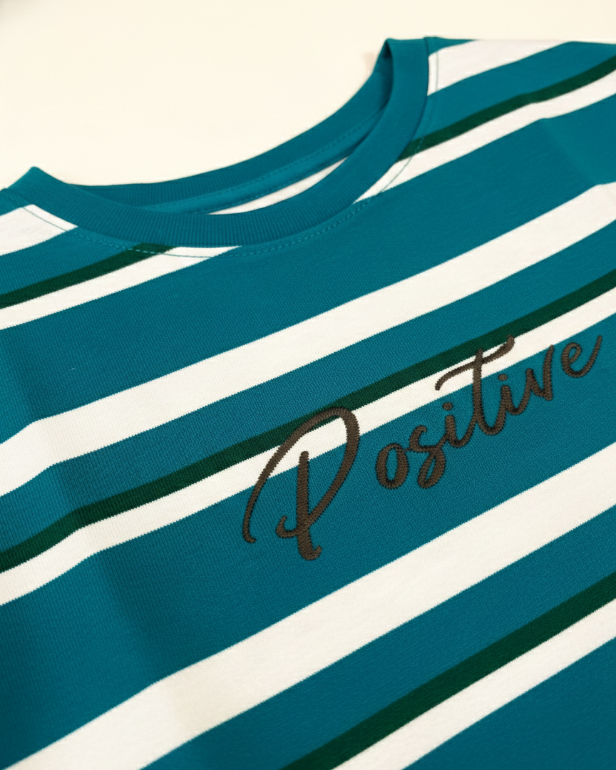 Teal and white striped shirt with 'Positive' text on a white background.