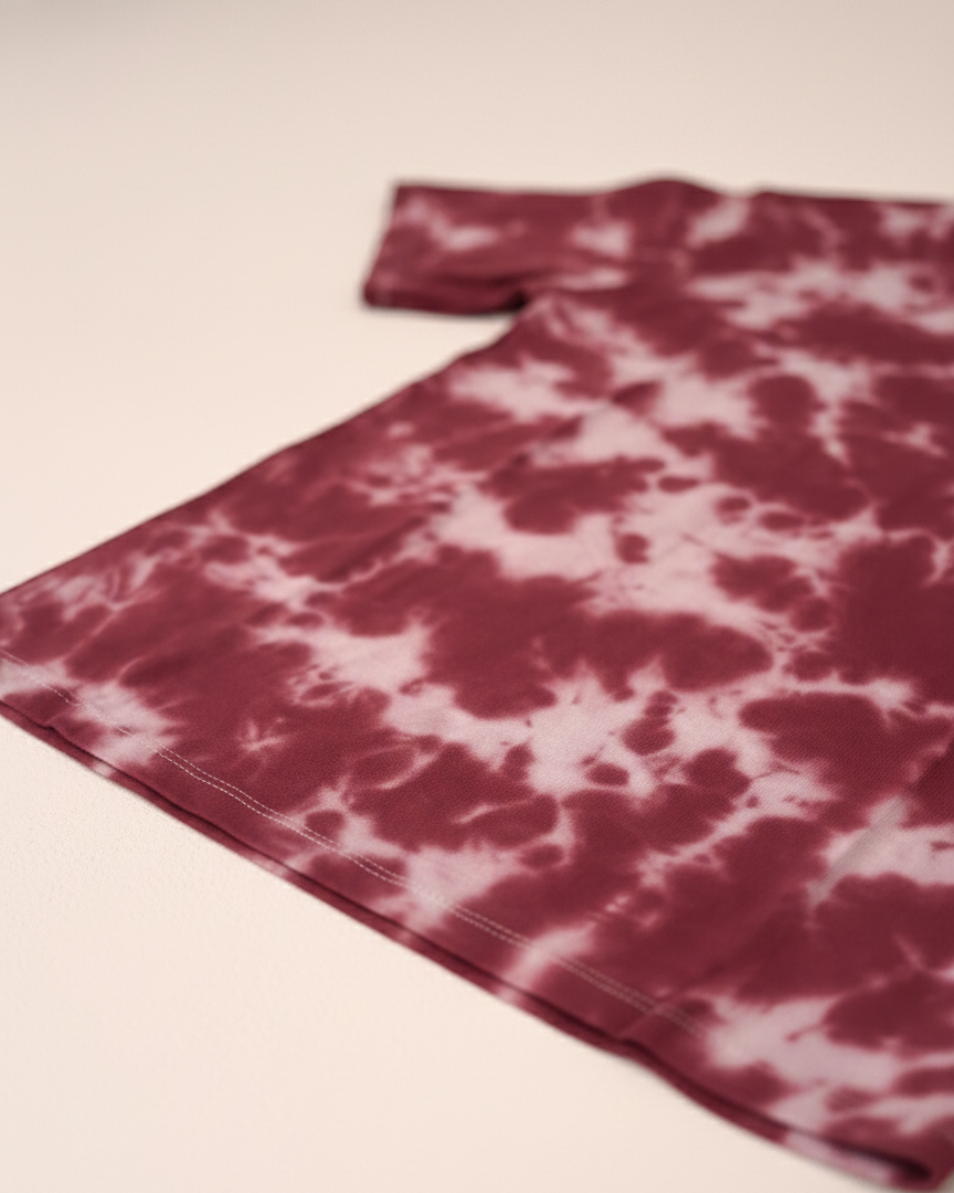 Tie-dye t-shirt with a maroon and white pattern on a light pink background