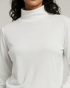 White mock neck tshirt worn by a person on a plain background