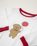 White shirt with a brown teddy bear and red balloon design on a white background
