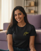 Woman sitting on the floor in a living room wearing a black t-shirt with a logo.