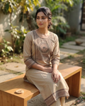 Woman sitting on a wooden bench outdoors with plants in the background
