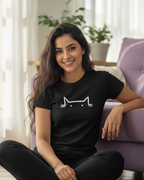 Woman sitting on the floor wearing a black t-shirt with a white graphic design.