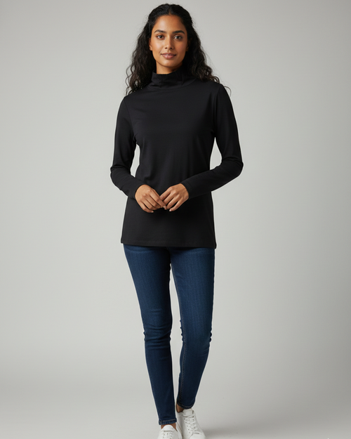 Woman wearing a black high neck and blue jeans on a gray background