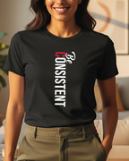 Woman wearing a black t-shirt with 'Be Consistent' text in a living room.