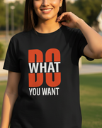 Woman wearing a black t-shirt with 'DO WHAT YOU WANT' text in an outdoor setting