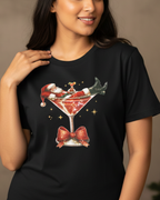 Woman wearing a black t-shirt with a Christmas-themed design in front of a decorated tree